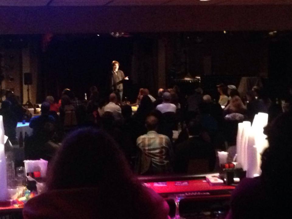 Ted Pettingell on stage in front of a full crowd.